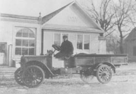 old photo of man driving car